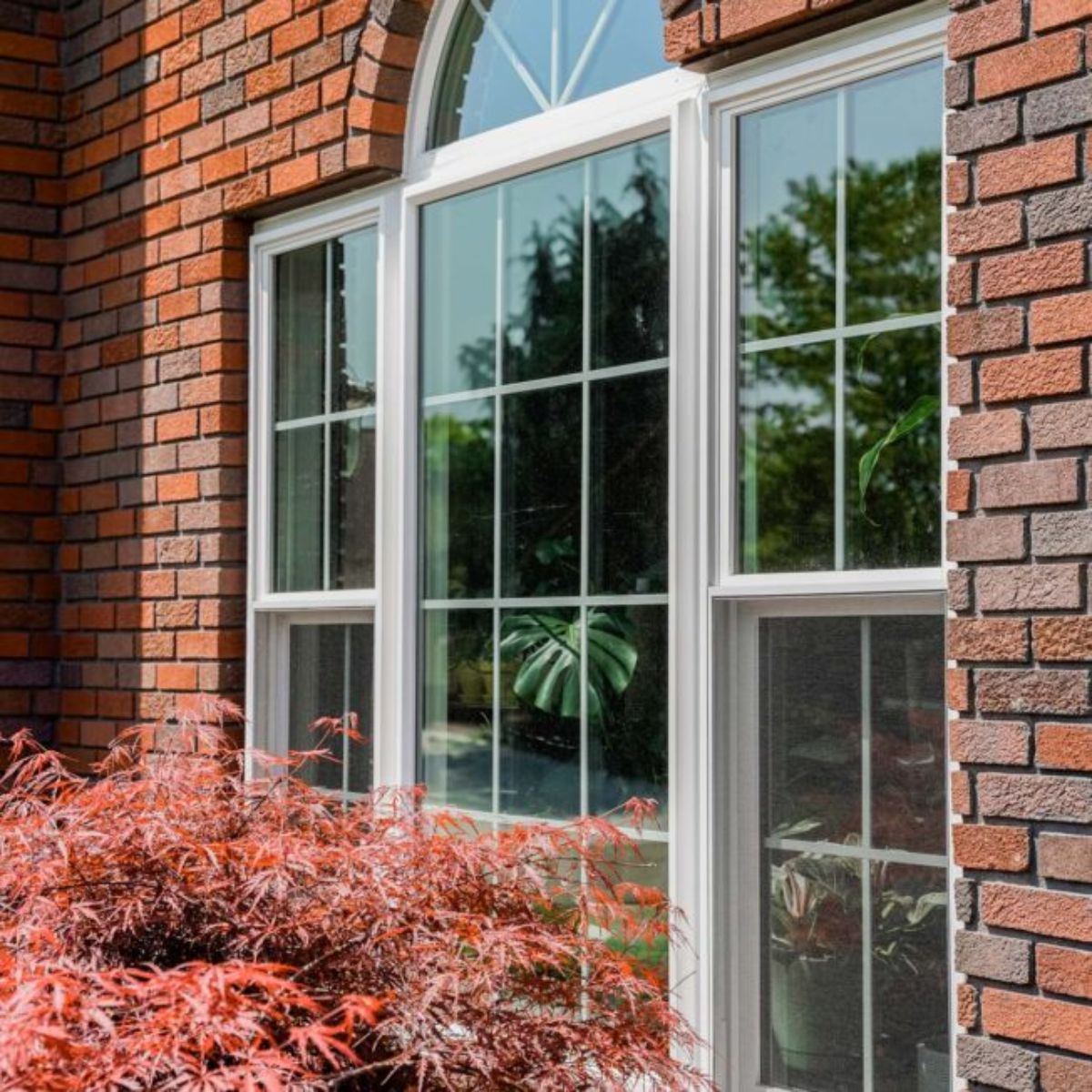 Traditional windows with an arch on a red brick house